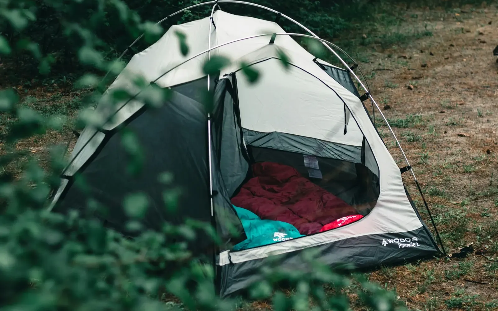 Carpa abierta con la colchoneta y la bolsa de dormir desplegadas adentro